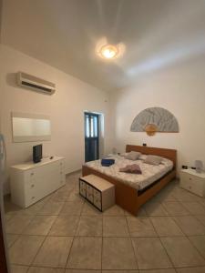 a bedroom with a bed and a dresser and a television at La Casa di Marco in Nuoro