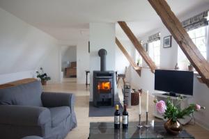 a living room with a fireplace and a couch at Reetdachkate Kiekut - a61544 in Altenhof