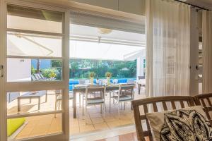 Un comedor con puertas corredizas de vidrio y una mesa y sillas. en Villa Niki, en Tróia