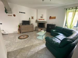 sala de estar con sofá verde y chimenea en La Casa di Marco, en Nuoro