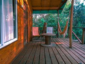 porche con hamaca, mesa y sillas en Cabaña Megara - Complejo Marea en Tigre
