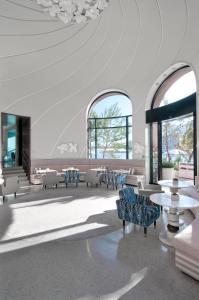 a lobby with tables and chairs and windows at Monte-Carlo Beach in Roquebrune-Cap-Martin