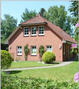 uma casa de tijolos vermelhos com um jardim verde em 2 Zimmer Business Wohnung mit Terrasse em Ahrensburg