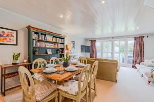 a dining room with a table and chairs and a couch at Mayfly Lodge in South Cerney