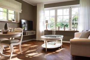 a living room with a table and chairs and a couch at Gut Moorbeck in Amelhausen