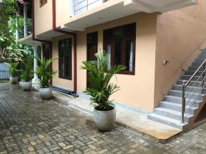 a building with potted plants in front of it at Kumar guest house & apartment in Unawatuna