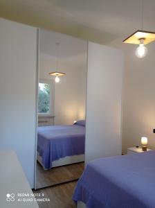 a bedroom with a blue bed and a mirror at Casafischea 21 Via Venino 21 B in Moneglia