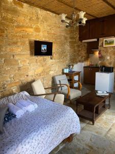 una camera con letto e parete in pietra di Pachna Studios - Village Life a Limassol