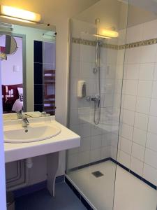a bathroom with a sink and a shower at Hotel les Commercants in Clermont-Ferrand +45 photos