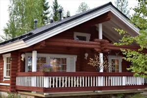 a log cabin with a porch and a balcony at Peikonpesä in Syöte