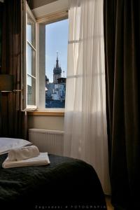 sypialnia z łóżkiem oraz okno z budynkiem w obiekcie Saint Thomas Corner - by Upstairs w Krakowie