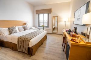 a hotel room with a large bed and a desk at Aram Hotel - AlMeshael Exit 18 in Riyadh
