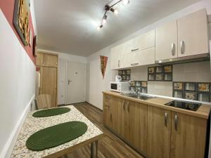 a kitchen with wooden cabinets and a counter top at Autumn Bliss Apartment in Timişoara