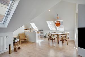 uma cozinha e sala de jantar com mesa e cadeiras em Bath tub penthouse in the city em Aalborg