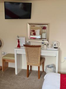 桑威治的住宿－Chilton Villa B&B，一张桌子、椅子、镜子和一张床