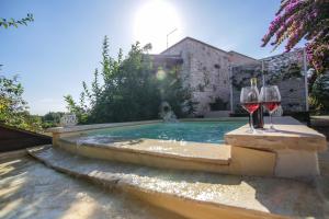 una piscina con 2 copas de vino y una botella de vino en Trullo Madia e Dimora Giorgio, en Ceglie Messapica