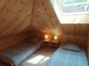 a bedroom with two beds in a wooden cabin at Le Carré de Bois in Briançon