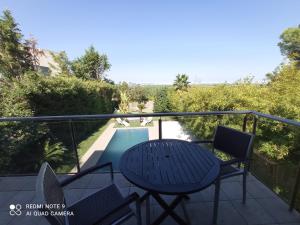 奇瓦的住宿－Villa Moderna，一个带桌椅的阳台和一个游泳池