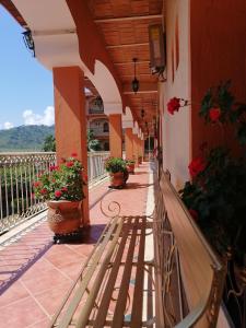 un porche avec un banc sur un bâtiment fleuri dans l'établissement Hotel Providencia, à Talpa de Allende