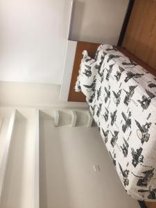 Dormitorio blanco con cama con manta en C&L Apartment, en Cuenca