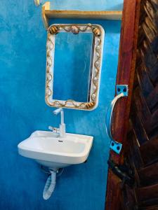 a bathroom with a sink and a mirror at Kasuku Villa in Jambiani
