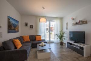 ein Wohnzimmer mit einem Sofa und einem Flachbild-TV in der Unterkunft Ferienwohnung Blickfang in Garmisch-Partenkirchen