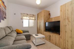 een woonkamer met een bank en een flatscreen-tv bij CASA ADA in Melenara
