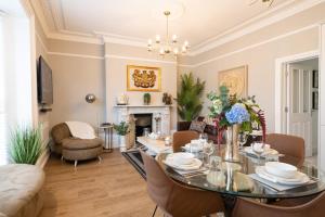 a dining room with a table and chairs and a fireplace at The Regal Apartment in Royal Tunbridge Wells
