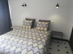 uma cama com duas almofadas e uma mesa num quarto em Edificio Coral em Albufeira