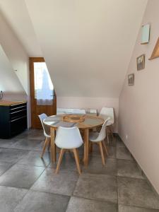 a dining room with a table and white chairs at Chez Pépé in Génos