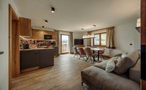 een woonkamer met een bank en een keuken bij Alpin Apartement G'ret in Flachau