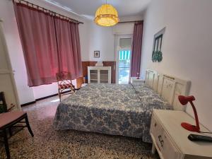 a bedroom with a bed and a table and a lamp at Villa Pina in Laigueglia