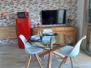 a dining room with a glass table and a red refrigerator at Vistas Melenara by CanariApartment - Beachfront Apartments with Balcony and Fast WiFi in Telde