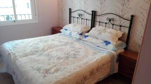 een slaapkamer met een bed met een bloemenbed bij Albaida II Bajo G Apartamento Nerja in Nerja