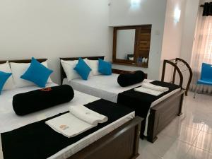 una camera con due letti con cuscini blu di Sobha Holiday Home a Anuradhapura