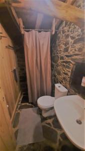 a stone bathroom with a toilet and a sink at Casa de Cima in Lousã