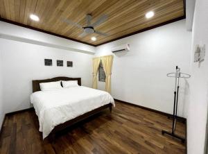 um quarto com uma cama e piso em madeira em The Venus - Spacious Wooden TOP Floor Apartment em Sitiawan