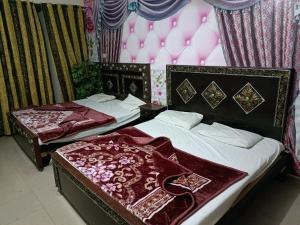 duas camas num quarto com uma parede com balões em New Hajveri Hotel Lahore em Lahore