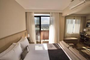 a hotel room with a large bed and a window at Staybridge Suites São Paulo, an IHG Hotel in Sao Paulo