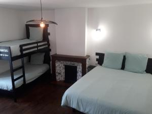 a bedroom with two bunk beds and a fireplace at La Maison d Antoine in Tarascon-sur-Ariège