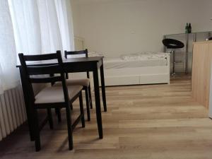 a dining room with a table and chairs and a bed at FerienWohnung A&S Heuchelheim in Heuchelheim