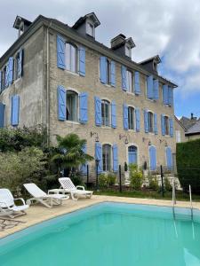 un bâtiment avec une piscine en face d'un bâtiment dans l'établissement Maison d'hôtes Le Couvent, à Bagnères-de-Bigorre