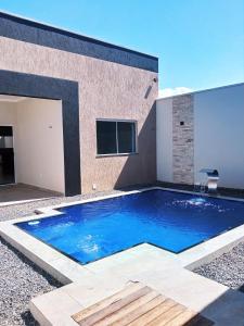 una gran piscina azul frente a un edificio en Casa Marilago en Camocim