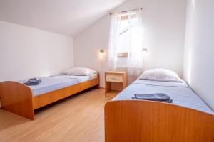 dwa łóżka pojedyncze w pokoju z oknem w obiekcie Apartments Irini w mieście Nijvice