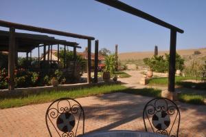eine Terrasse mit einem Tisch und Stühlen im Garten in der Unterkunft ferme Walila in Douar Doukkara