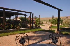 a patio with a table and chairs in a garden at ferme Walila in Douar Doukkara