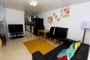 ein Wohnzimmer mit einem Sofa, einem Tisch und einem TV in der Unterkunft Comfortable stay in Shirley, Solihull - Room 3 in Olton