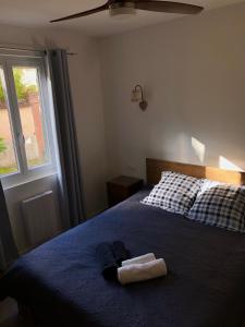 una camera da letto con un letto con una coperta blu e una finestra di Au repos des vignes, chambres d'hôtes a Rosheim