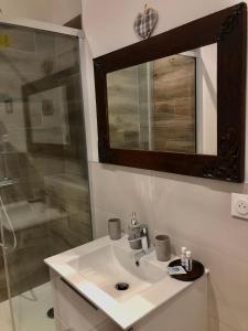 a bathroom with a sink and a shower and a mirror at Au repos des vignes, chambres d'hôtes in Rosheim