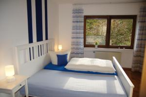 una camera con un letto bianco e una finestra di Gasthof Schumacher Hotel garni a Freudenberg